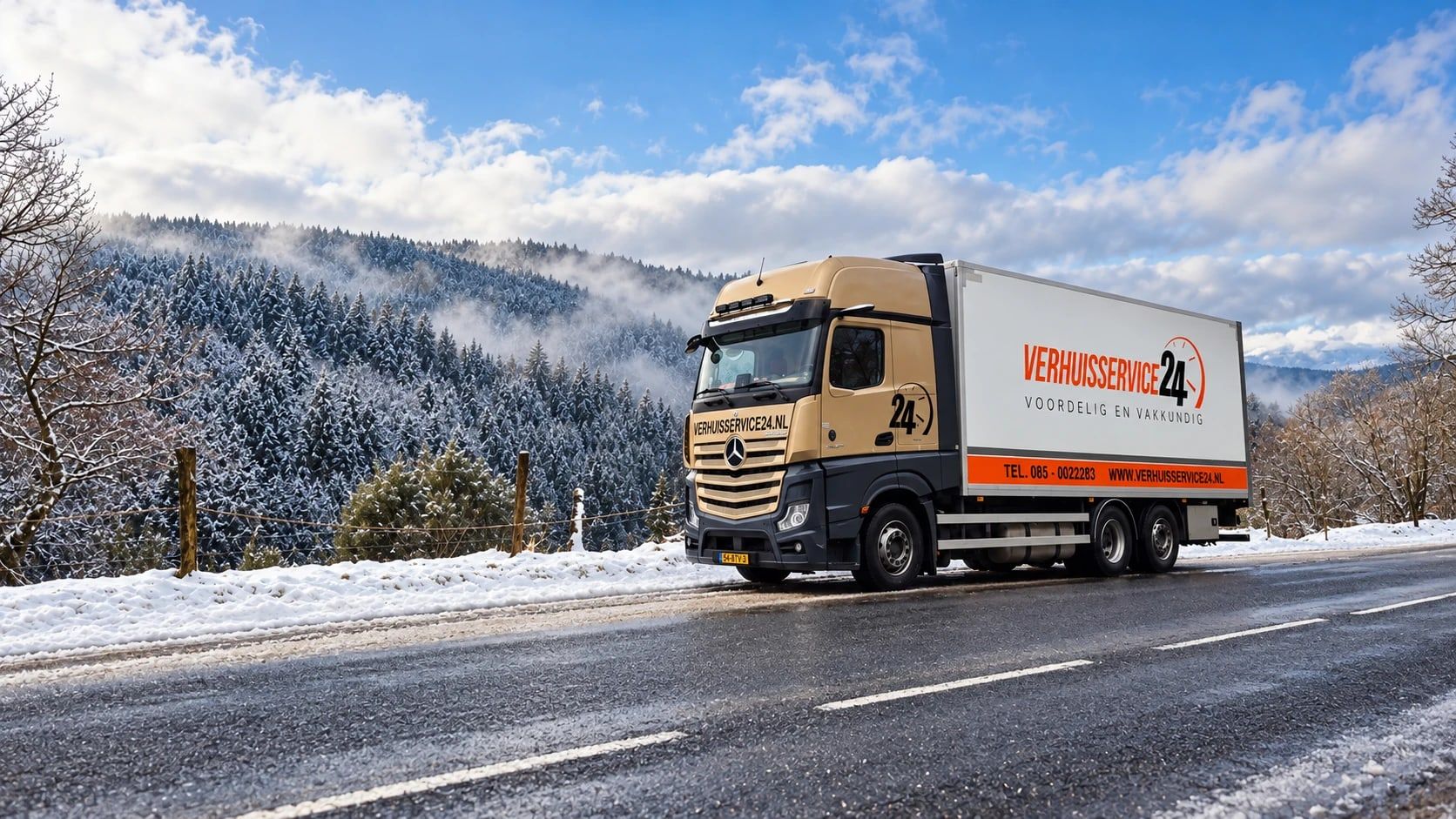 Vrachtwagen van Verhuisservice24 onderweg door een besneeuwd berglandschap