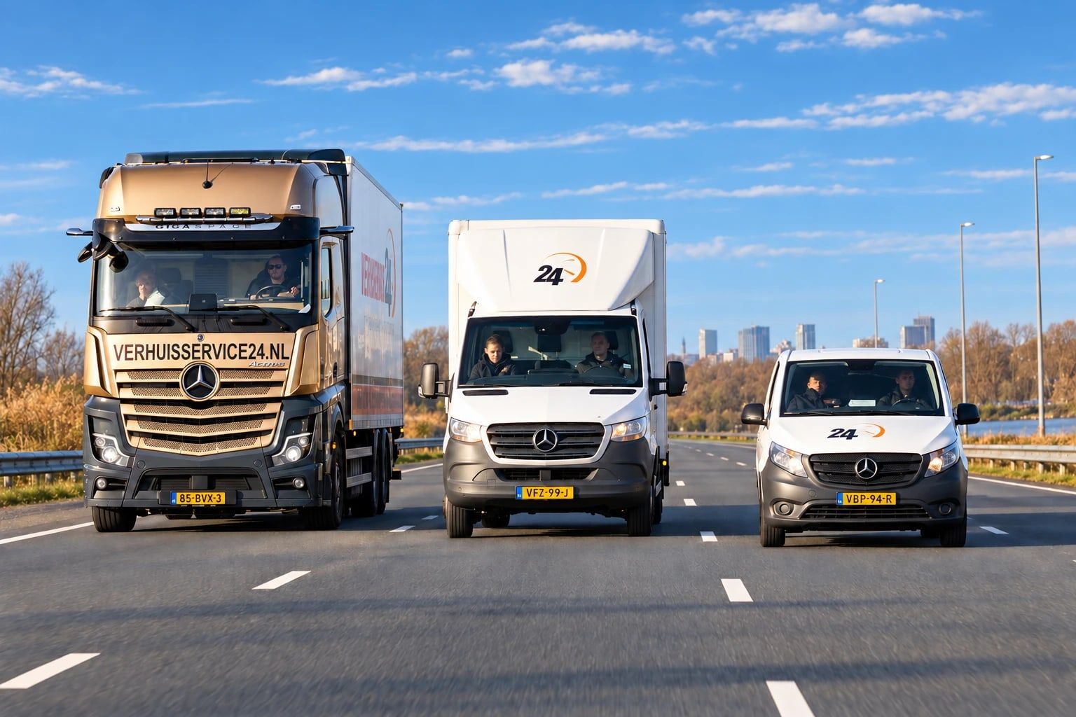 Vrachtwagen, bakwagen en bestelbus van Verhuisservice24 rijden naast elkaar over de weg