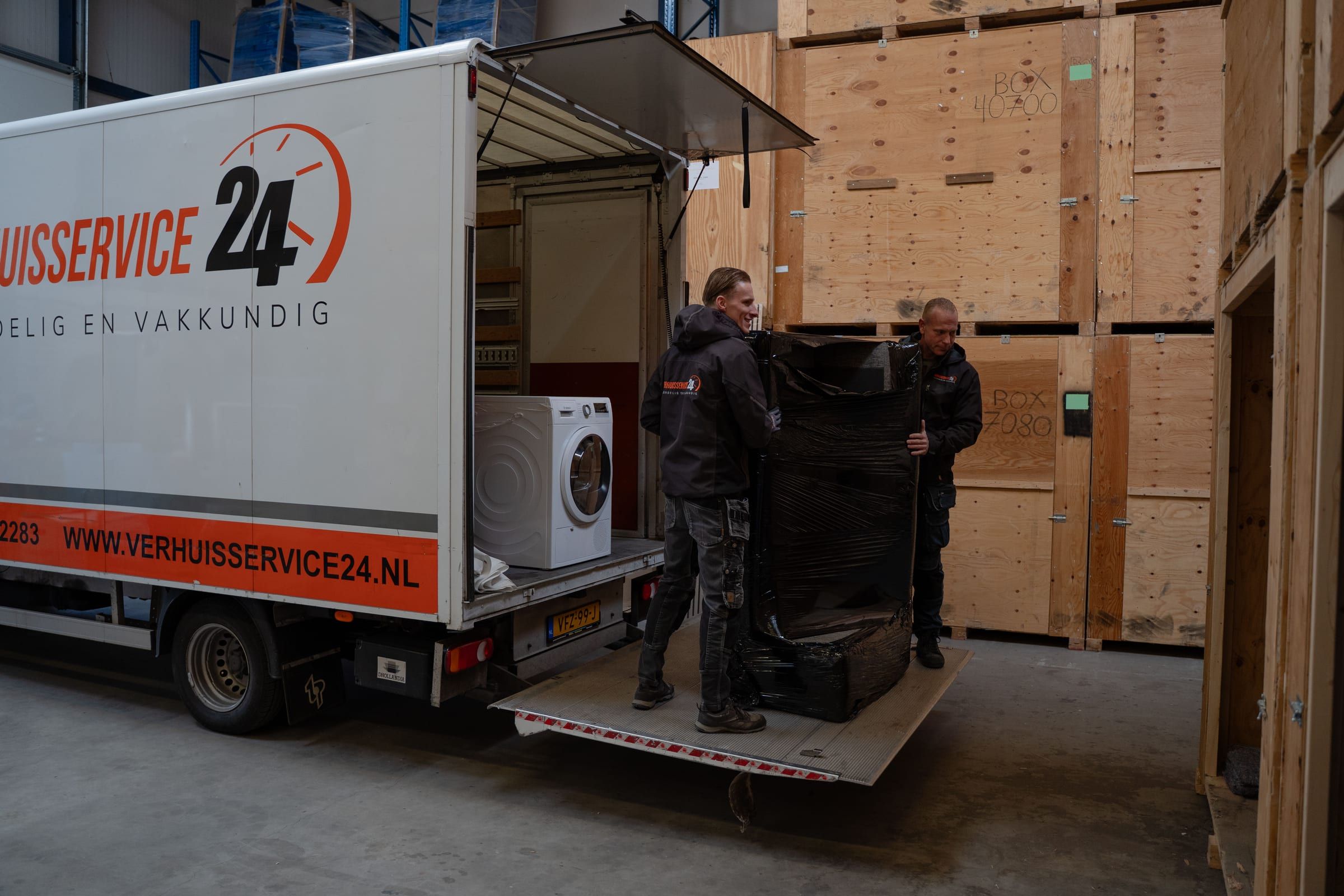 Verhuizers laden een bakwagen uit bij de opslag van Verhuisservice24
