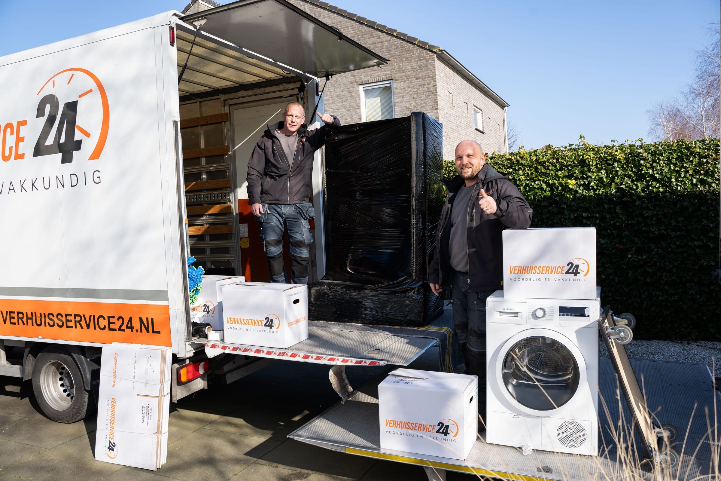 Twee verhuizers van Verhuisservice24 bij de bakwagen, duim omhoog